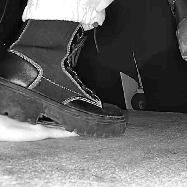 Woman unaware steps on hand with chunky-heeled black ankle boots in cinema 2