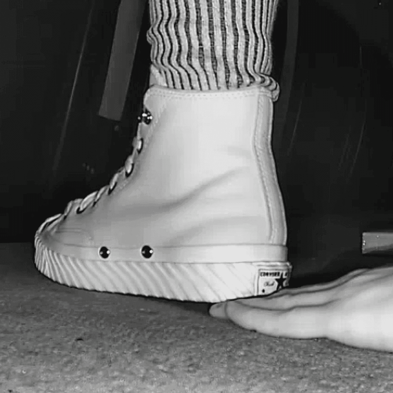 Woman in high-top Converse unaware hand trample + sneaker unaware hand trample