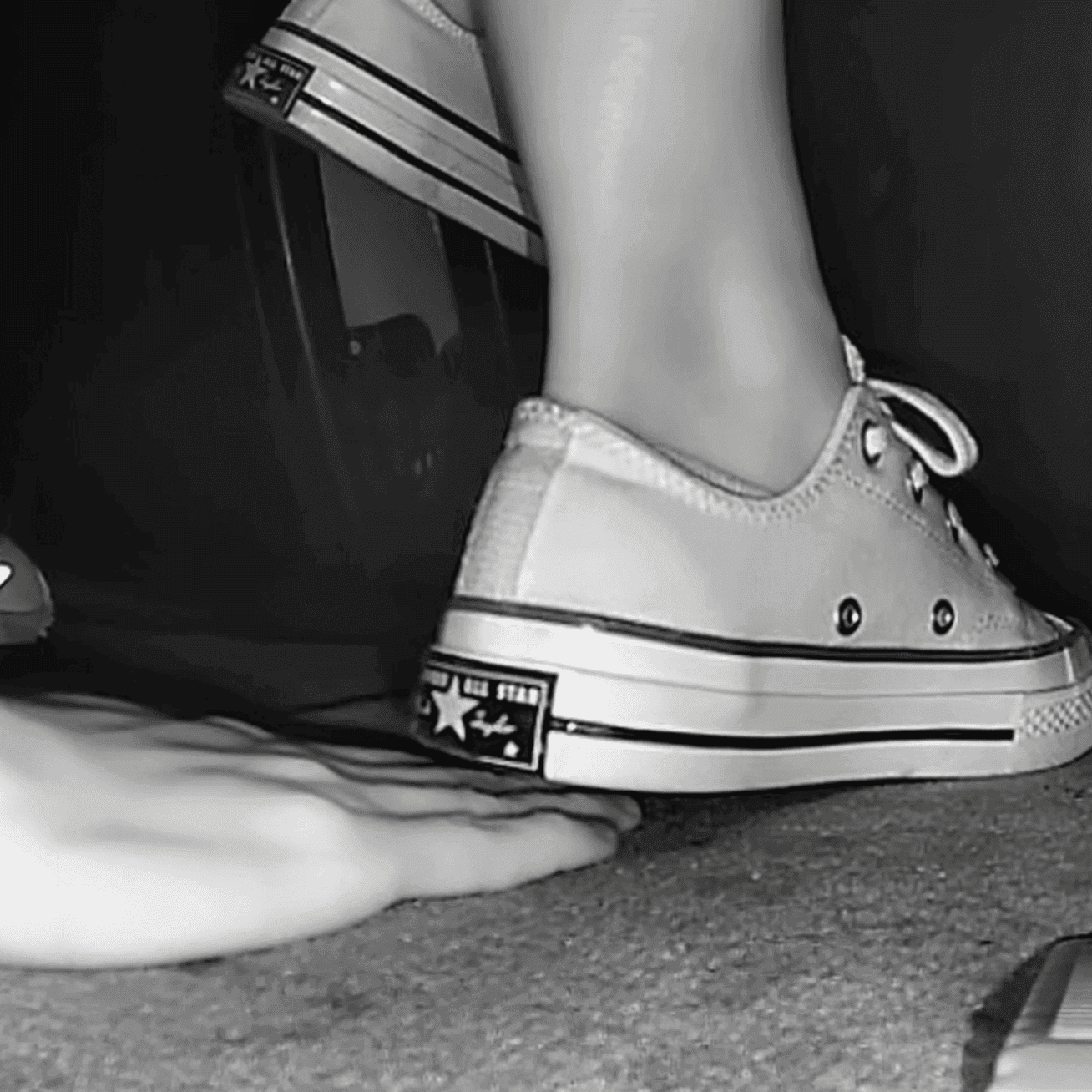 Woman in cinema wearing flat shoes + low-top Converse shoes unaware hand trample thumb 2