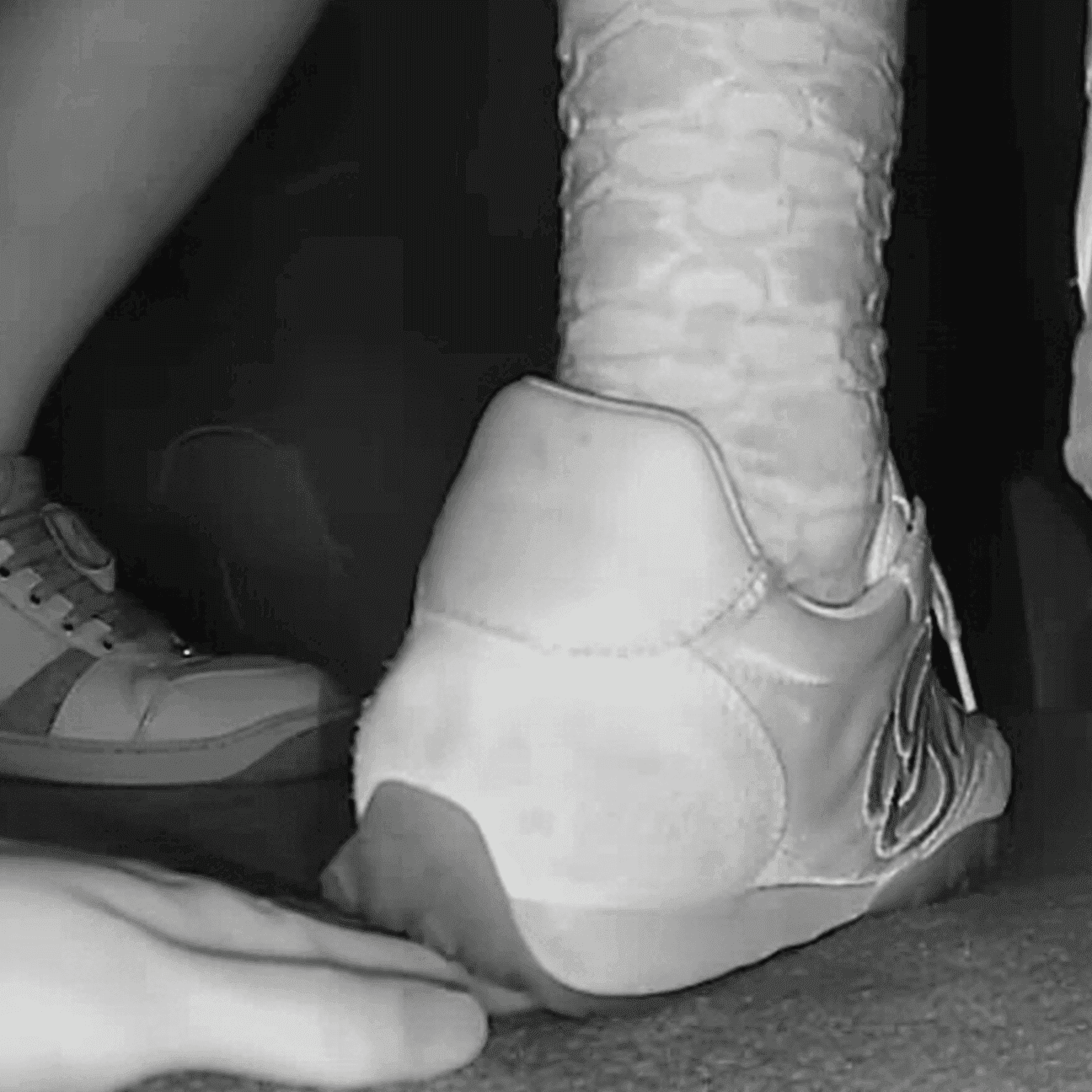 Woman unaware hand trample with sneakers and ankle boots in cinema
