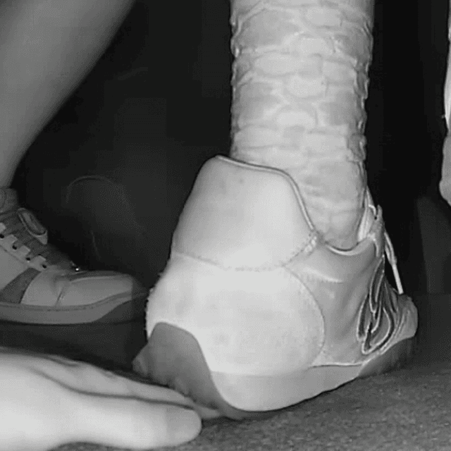 Woman unaware hand trample with sneakers and ankle boots in cinema 1