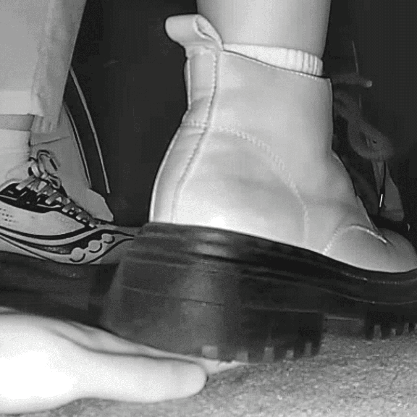 Woman in white socks and Martin boots unaware hand trample in cinema