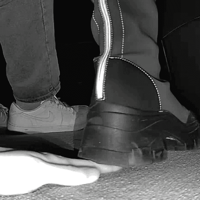 Woman with chunky-heeled knee-high boots unaware hand trample in cinema 3