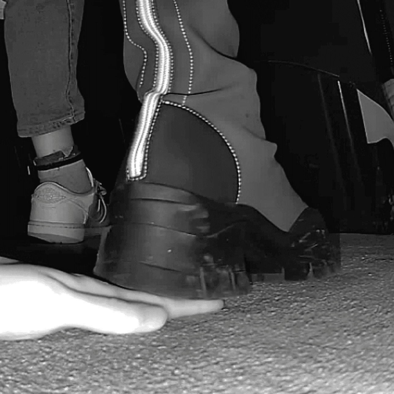 Woman with chunky-heeled knee-high boots unaware hand trample in cinema